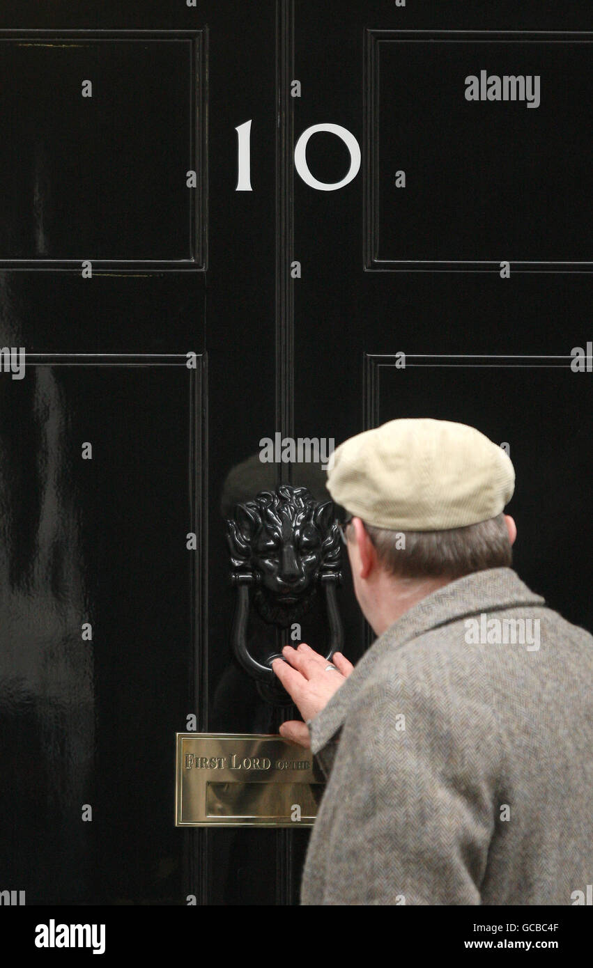 Ein Mann klopft an die Tür der Downing Street 10 in London, als der konservative Vorsitzende David Cameron und sein liberal-demokratischer Amtskollege Nick Clegg heute in der Downing Street 10 aufgefordert wurden, sich mit den Vorwürfen der Mobbing von Mitarbeitern zu befassen. Stockfoto