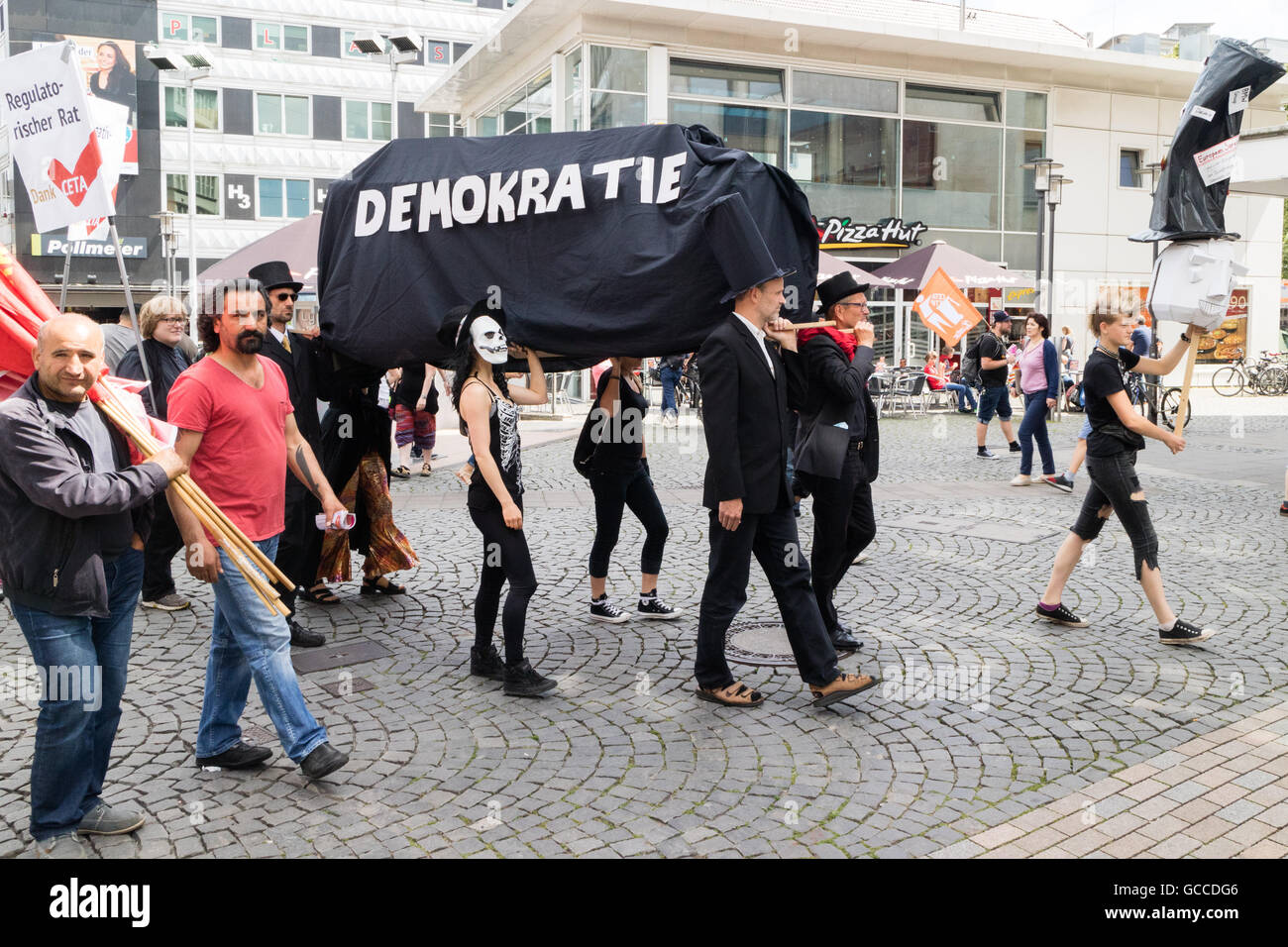 Demonstranten demonstrieren gegen die CETA/TTIP Handelsabkommen mit einem mock Sarg, schlägt der Tod der Demokratie. Stockfoto