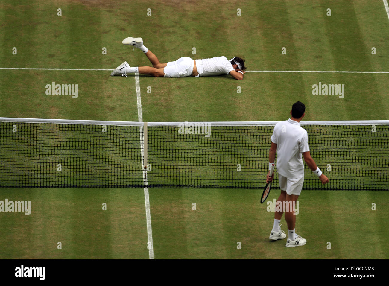 Roger Federer rutscht aus, als er Milos Raonic am 11. Tag der Wimbledon Championships beim All England Lawn Tennis and Croquet Club in Wimbledon gegenübersteht. Stockfoto