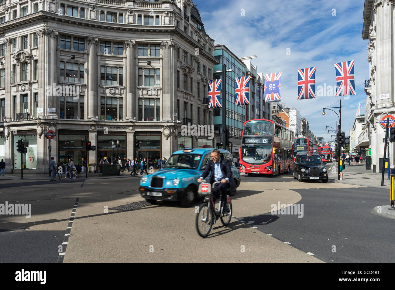 Verkehr und Pendler auf Radfahren durch Oxford Circus London City Busse Black Taxi Cab Stockfoto