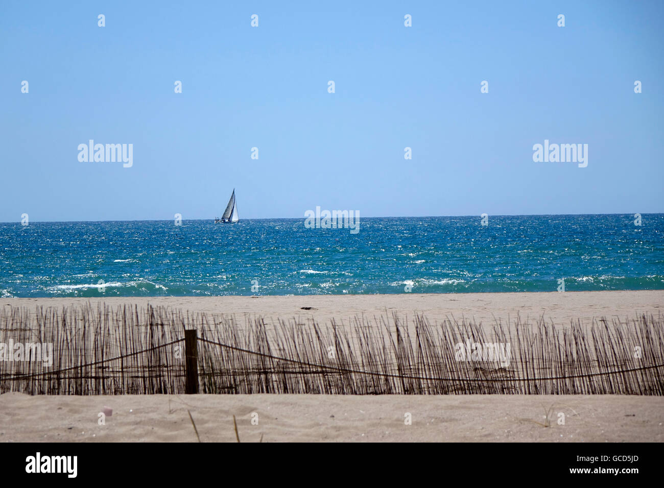 Ein Segelboot-Heels in den Wind einmal einen Strand zwischen Valencia und Barcelona im spanischen Mittelmeer. Stockfoto