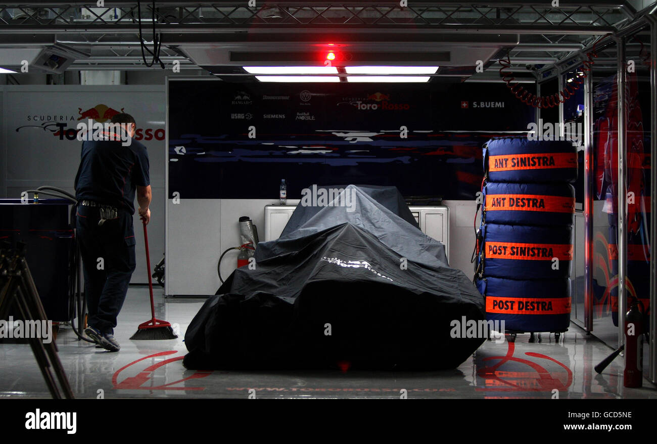 Nach den Renntagen auf dem Bahrain International Circuit in Sakhir, Bahrain, wird ein Mechaniker in der Garage von Torro Rosso aufgeräumt. Stockfoto