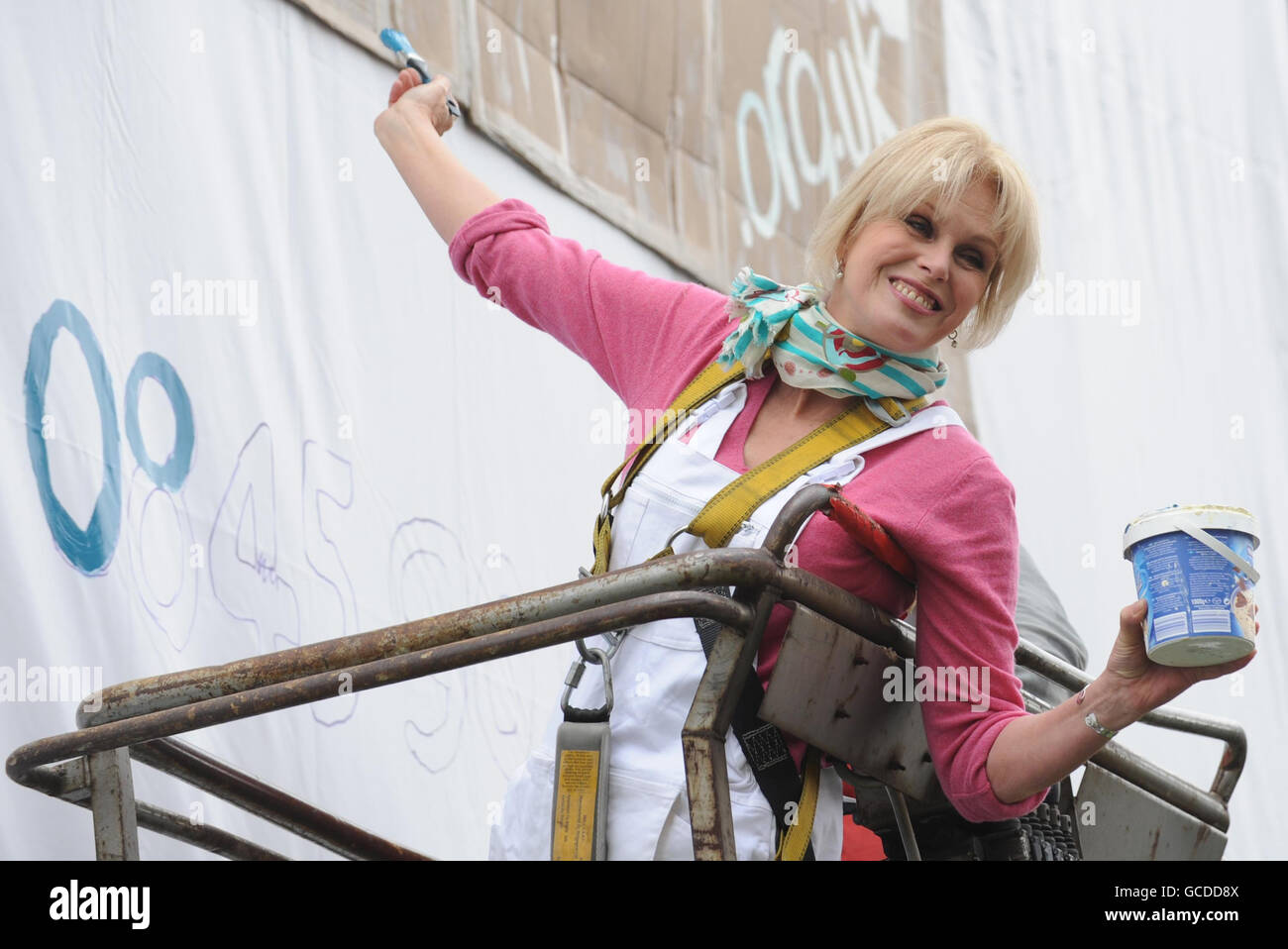 Schauspielerin Joanna Lumley hilft, eine Plakatwand in London zu malen, die heute die Thames Reach Kampagne anwirbt, um die Aufmerksamkeit auf Londons Obdachlose am Thames Reach Obdachlose Hostel, Bondway, London, zu lenken. Stockfoto