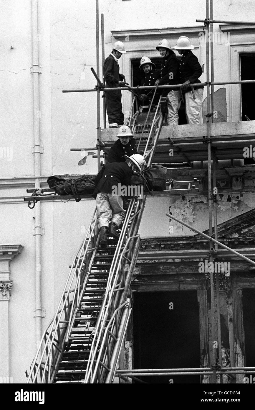 Feuerwehrleute, die eine von zwei Leichen entfernen, die bisher in den verbrannten Resten der iranischen Botschaft in London gefunden wurden. Die Leiche, in einen dunkelgrünen Leichensack gewickelt, wurde von einem Fenster im zweiten Stock des Gebäudes im Princes Gate, Kensington, abgesenkt und von einem Leichenwagen mitgenommen. Stockfoto