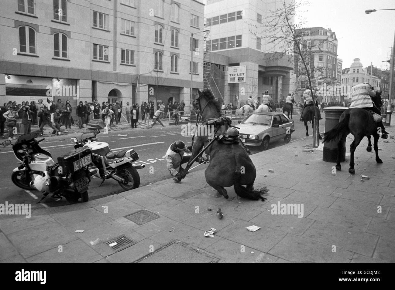 Ein Polizist fällt von seinem Pferd inmitten der Szenen der Unruhen, nachdem eine Anti-Umfrage-Steuer-Demonstration in eine pitchige Schlacht um Trafalgar Square ausbrach. Stockfoto