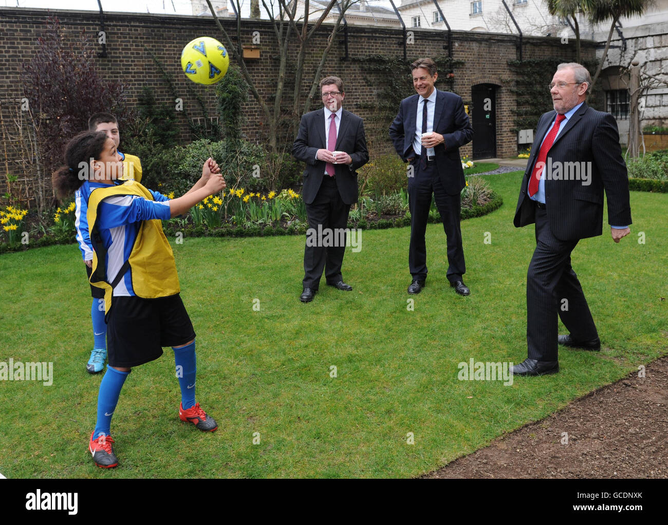 2018 WM-Bid-Botschafter Richard Caborn MP spielt Fußball im Garten der Downing Street 10, London, Zusammen mit Kindern der Bishop Challoner School in London und dem Sportminister Jerry Sutcliffe (Mitte) und dem Kulturminister Ben Bradshaw unterzeichneten sie und Premierminister Gordon Brown ein riesiges England-Hemd, um ihre Unterstützung für das englische WM-Team in diesem Jahr zu zeigen. Stockfoto