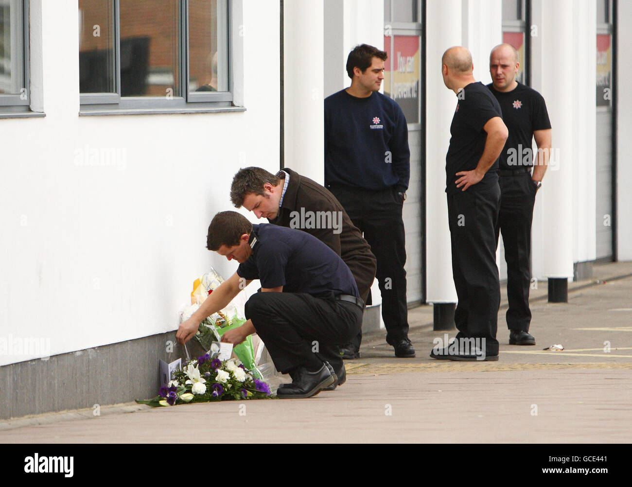 Ein Feuerwehrmann legt Blumen vor der Feuerwache in St. Marys in Southampton, nachdem die Feuerwehrleute Alan Bannon und James Shears, die in der Station arbeiten, bei einem Brand in Shirley Towers im Shirley-Gebiet der Stadt über Nacht getötet wurden. Stockfoto