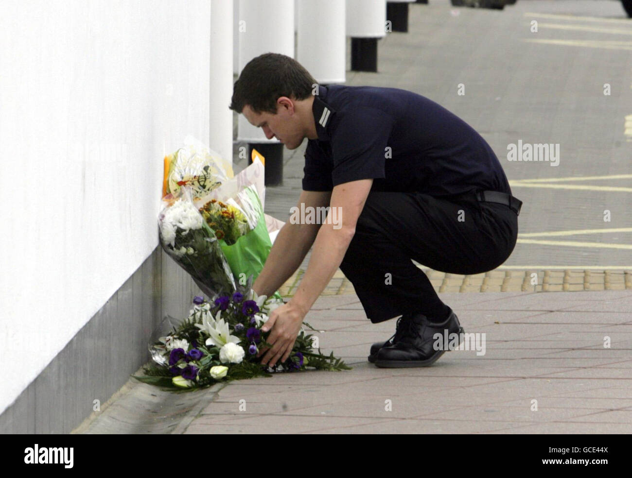Ein Feuerwehrmann legt Blumen vor der Feuerwache in St. Marys in Southampton, nachdem die Feuerwehrleute Alan Bannon und James Shears, die in der Station arbeiten, bei einem Brand in Shirley Towers im Shirley-Gebiet der Stadt über Nacht getötet wurden. Stockfoto