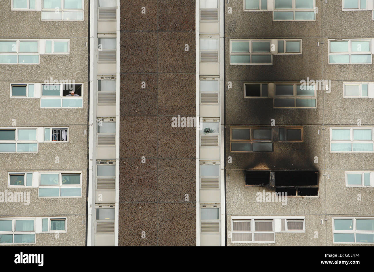 Ein Bewohner der Shirley Towers in Southampton blickt auf das verkohlte Gebäude, nachdem die Feuerwehrleute Alan Bannon und James Shears dort über Nacht bei einem Brand getötet wurden. Stockfoto