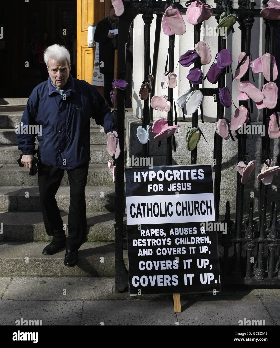 Ein Mann (Name nicht bekannt) passiert bei der Ostersonntagsmesse in der St. Mary's Pro-Cathedral in Dublin Kinderschuhe, die von Überlebenden von klerikalen Misshandlungen in Geländer gehangen wurden. Seit einem Bombenbericht im November, in dem jahrzehntelange Misshandlungen von Kindern in Irland detailliert beschrieben und festgestellt wurde, dass pädophile Priester von Gleichaltrigen und Beamten abgeschirmt wurden, hat der Druck auf die katholische Kirche zugenommen. Stockfoto