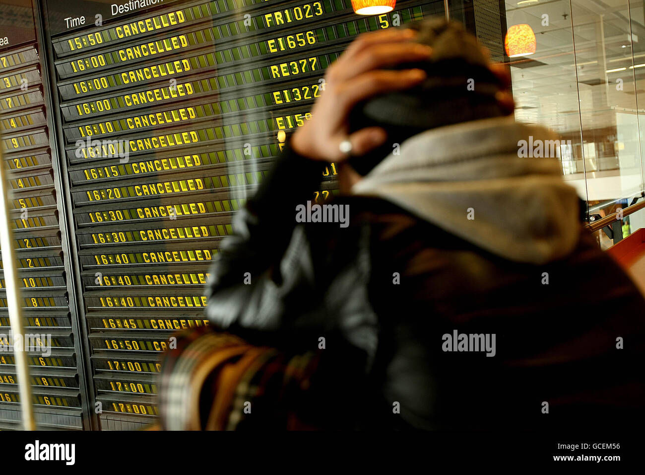Vulkanische Asche verursacht Reiseunterbrechungen. Ein Reisender wartet am Flughafen Dublin auf Informationen. Stockfoto