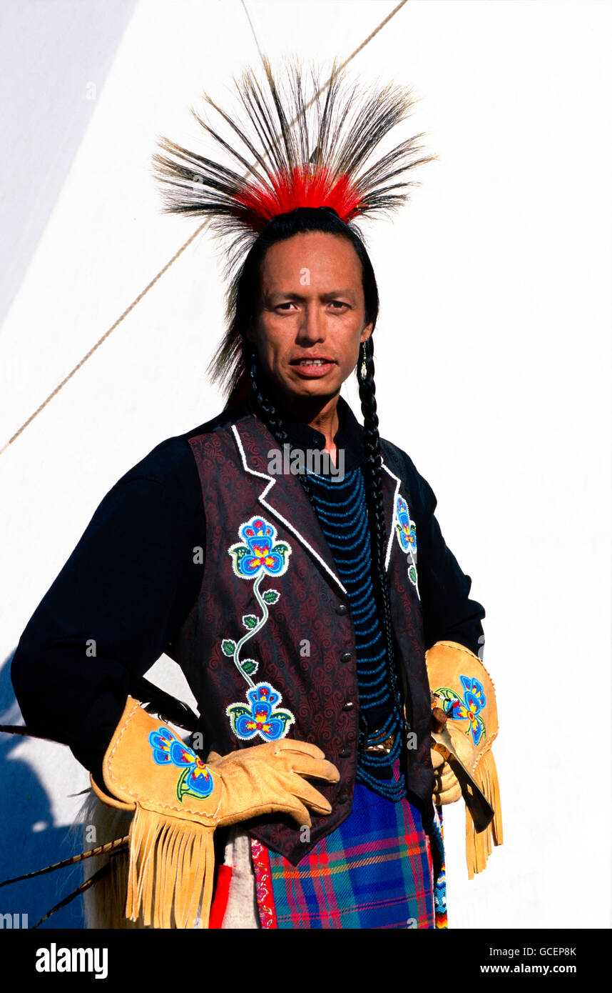 Gebürtige amerikanische Mann trägt zeremonielle Kleid vor Tipi, USA Stockfoto