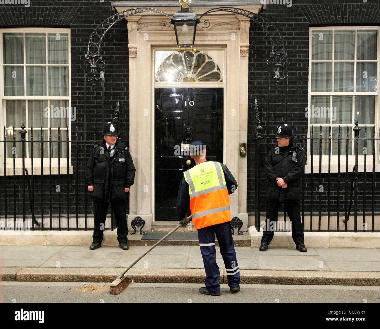 Eine Reinigungskraft außerhalb der Downing Street, während Medienvertreter nach der Ankündigung eines aufgehängten Parlaments nach einem ergebnislosen Ergebnis der am stärksten umkämpften Parlamentswahlen seit einer Generation auf Nachrichten warten. Stockfoto