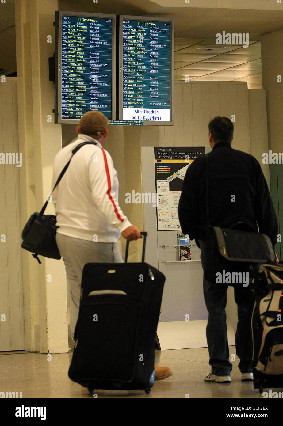 Passagiere schauen sich ein Abflugbrett in einem nahe verlassenen Terminal One am internationalen Flughafen Birmingham an, als Großbritannien mit einem weiteren Reisechaos konfrontiert war, nachdem die meisten Flüge in und aus Großbritannien bis heute Abend von der isländischen Vulkanaschewolke geerdet wurden. Stockfoto