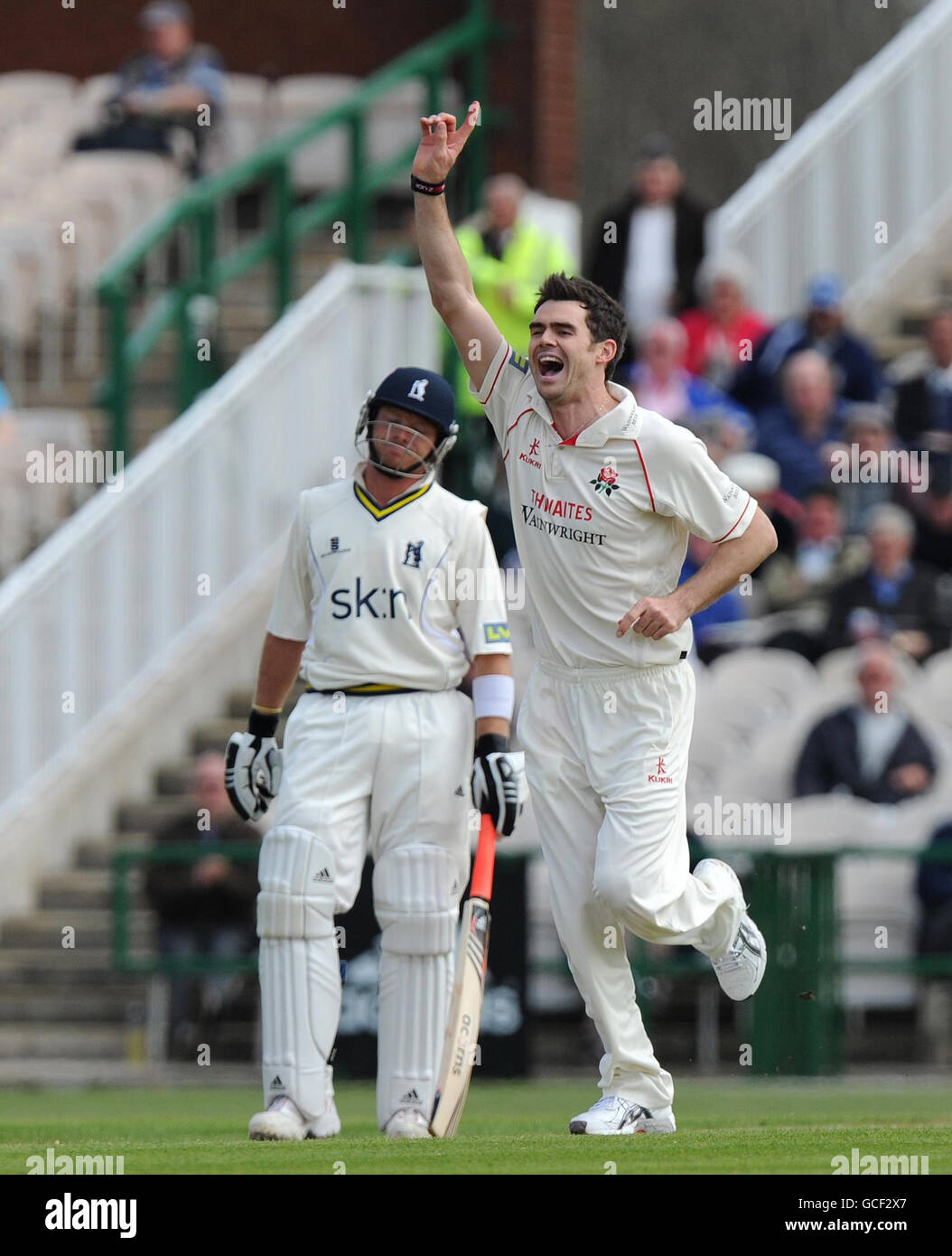 James Anderson von Lancashire feiert die Teilnahme an der Partie von Graham Trott in Warwickshire, während Ian Bell beim Spiel der LV County Championship, Division One im Old Trafford Cricket Ground, Manchester, ansieht. Stockfoto