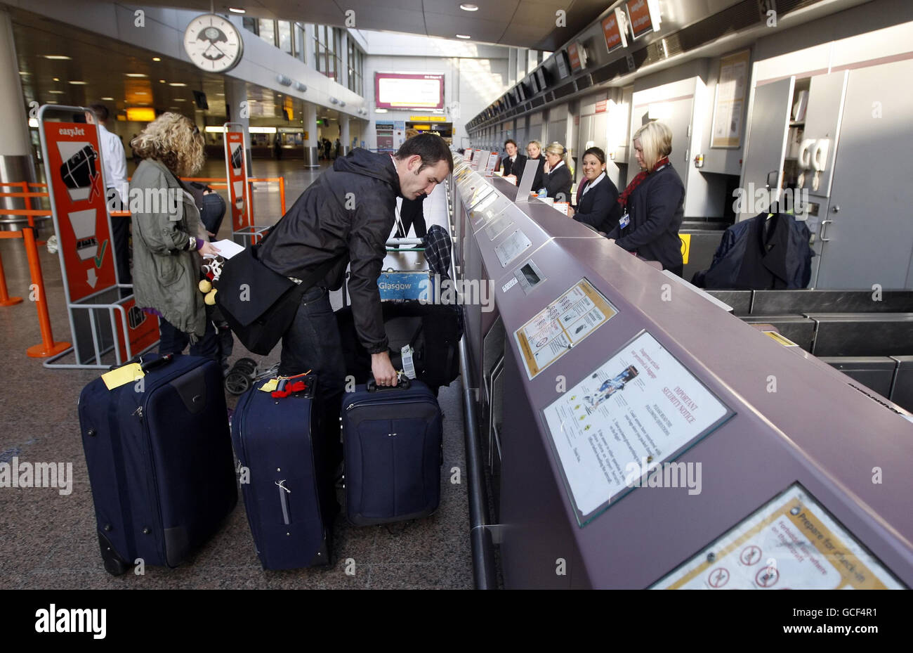 Passagiere checken am Flughafen Glasgow ein, nachdem der Himmel in Großbritannien wieder geöffnet wurde, und zwar inmitten eines anhaltenden Reigens über Flugbeschränkungen, die durch die Vulkanaschewolke verursacht wurden. Stockfoto