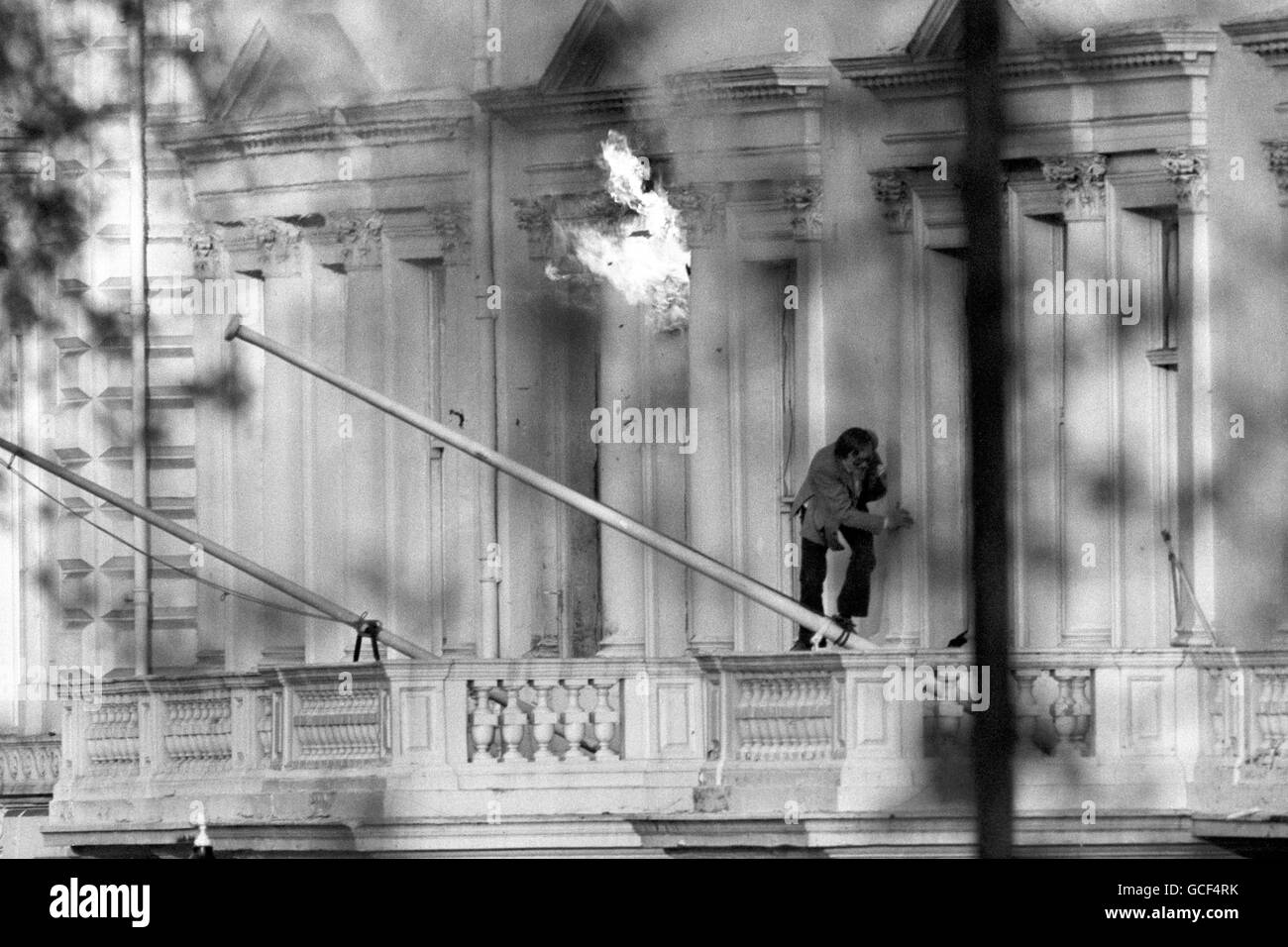 Der BBC-Tonaufrichter SIM Harris, eine der britischen Geiseln, kriecht in Sicherheit, als Flammen aus dem Fenster der iranischen Botschaft in London auflodern, als zwei Explosionen die sechstägige Belagerung des Gebäudes im Princes Gate beendeten. Vierzehn Geiseln wurden lebend herausgebracht und eine Reihe von Schützen festgenommen. Stockfoto