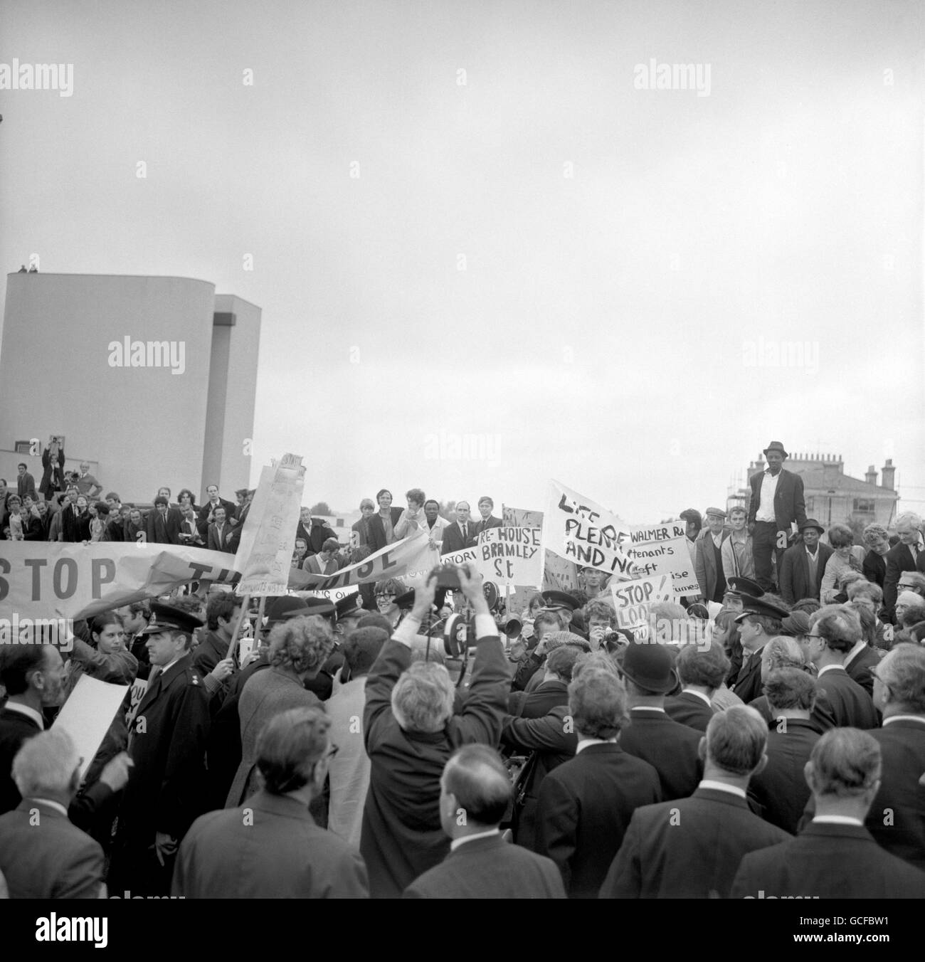 Wütend winkende Bannerwerbung umringt Michael Heseltine, Parlamentarischer Sekretär des Verkehrsministeriums, als er in Paddington Green ein Band schneidet, um die 2.5 Meilen lange Western Avenue Extension, Großbritanniens längste Hochstraße, zu eröffnen. Die Demonstranten, die die Zeremonie unterbrochen hatten, protestierten über die Auswirkungen der Straße auf ihre Lebensbedingungen und forderten eine Umbeehrung. Der erhöhte zweispurige Abschnitt der A40-Route im Westen Londons verläuft von Paddington nach North Kensington und wurde gebaut, um Staus am Shepherd's Bush durch den Verkehr von der Western Avenue zu entlasten. Stockfoto