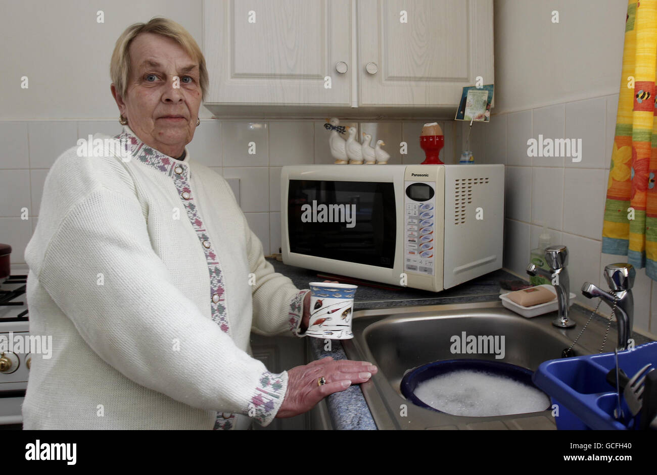 May Wilkins aus Westhoughton, Bolton, in ihrer Küche mit einer Mikrowelle, die explodierte, nachdem Diebe einen Stromstoß verursacht hatten, sagte heute ein Energieversorger. Stockfoto
