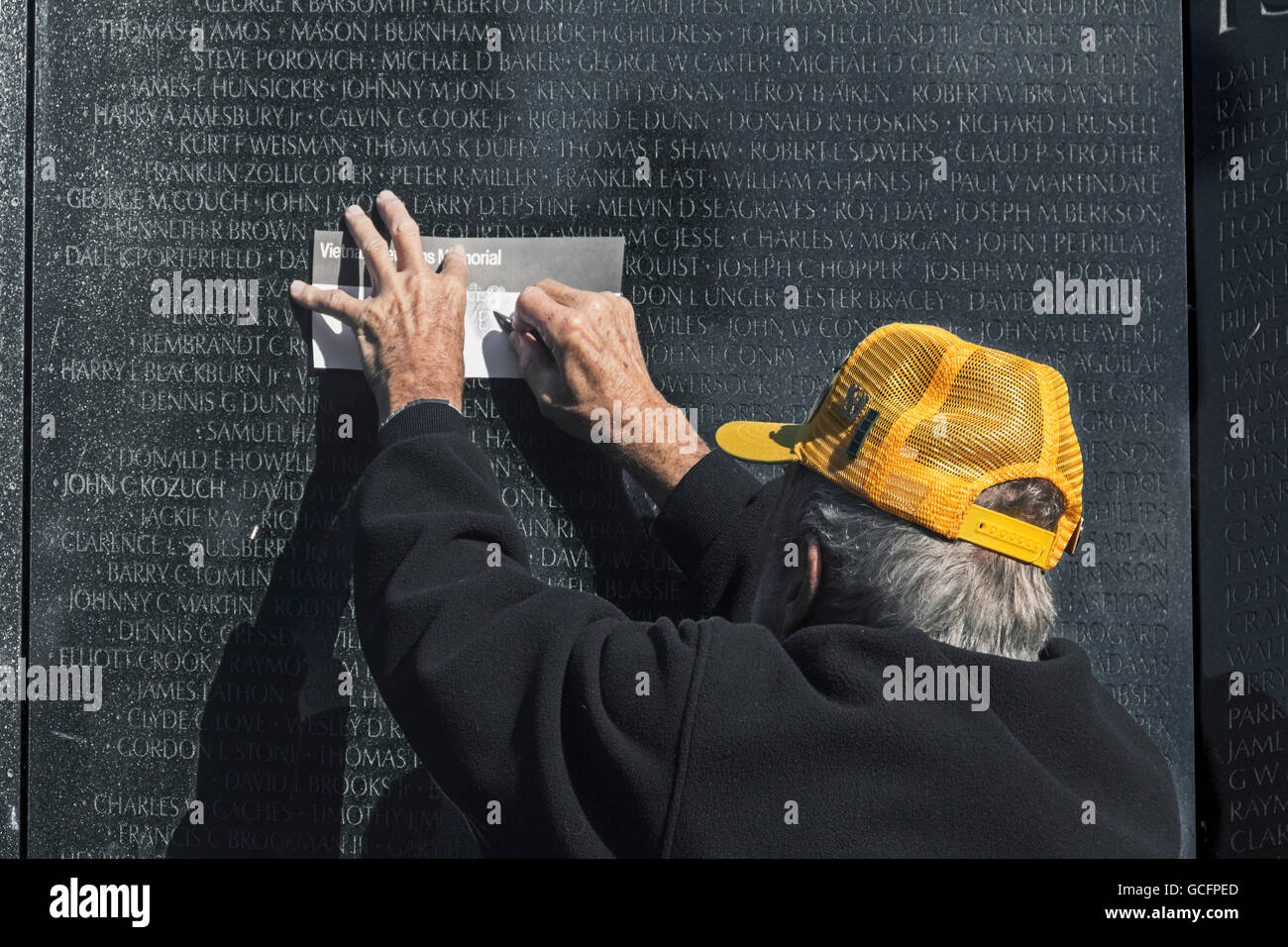 Vietnam-Krieg-Veteran Freiwilligen ist ein Reiben mit einem Graphitstift, einen Abdruck des Namens auf Mauer der Erinnerung zu erhalten Stockfoto