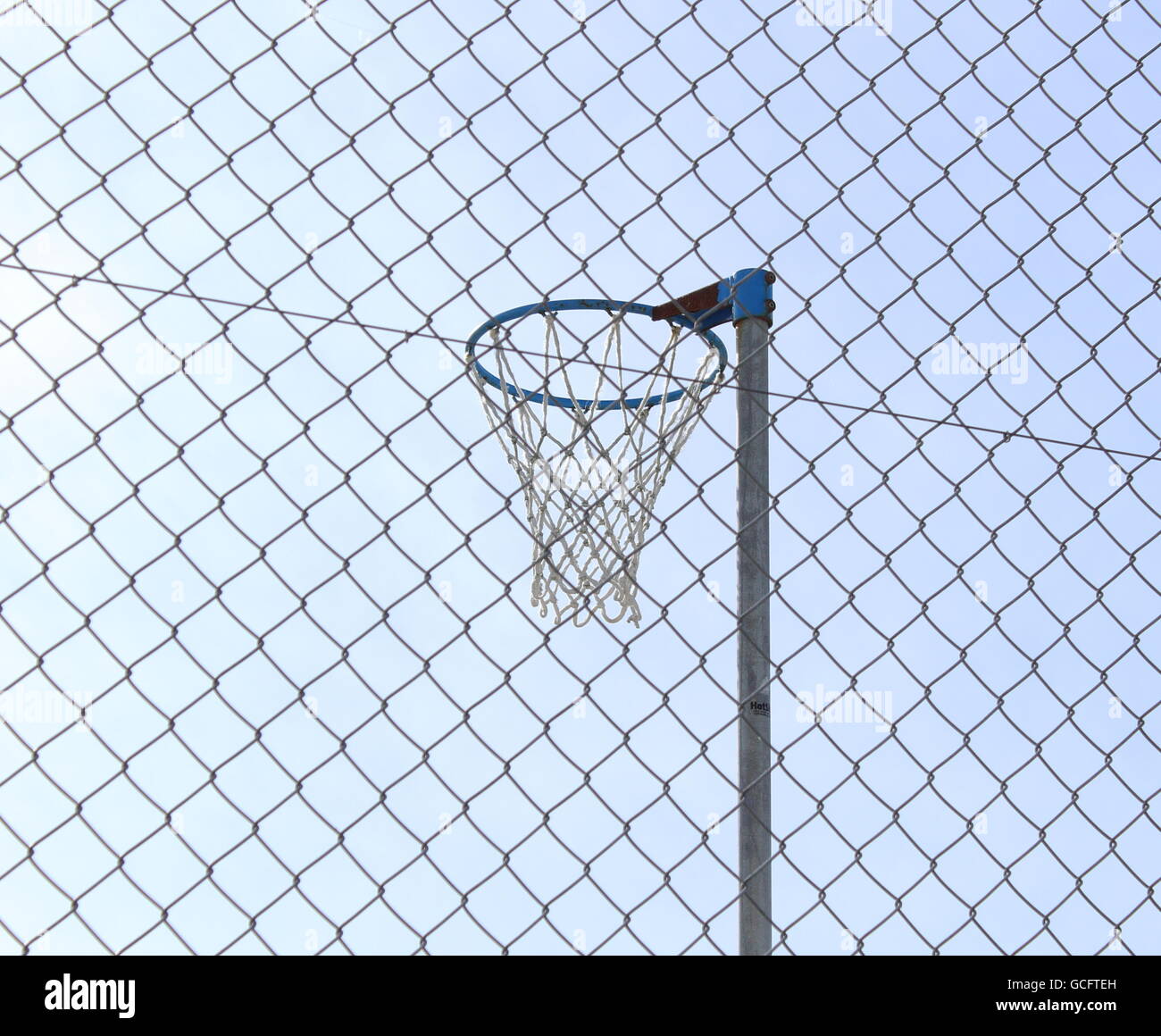 Ein Netball-Ring auf einem vollständig eingezäunten Spielplatz Stockfoto