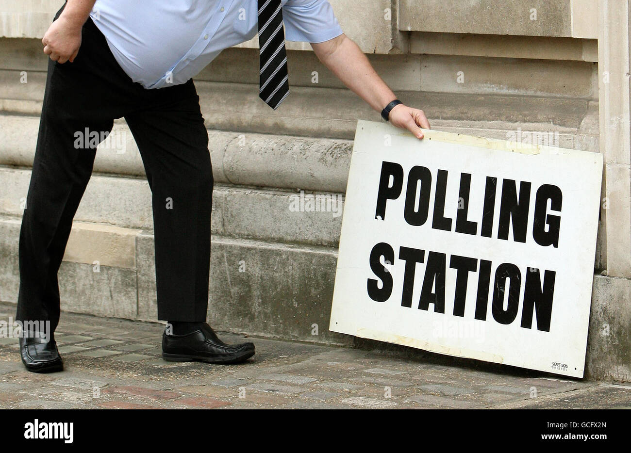 Ein Mitarbeiter stellt vor einem Wahllokal in der Methodist Central Hall, Westminster, London, ein Schild, da Wahllokale für die Parlamentswahlen geöffnet sind. Stockfoto