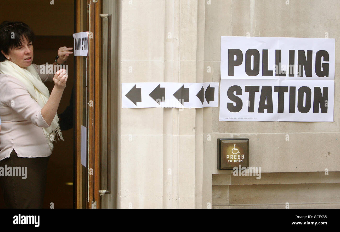 Ein Mitarbeiter positioniert ein Schild an der Tür eines Wahllokalen in der Methodist Central Hall in Westminster, im Zentrum von London, als bei den Parlamentswahlen in ganz Großbritannien Wahlen anstanden. Stockfoto