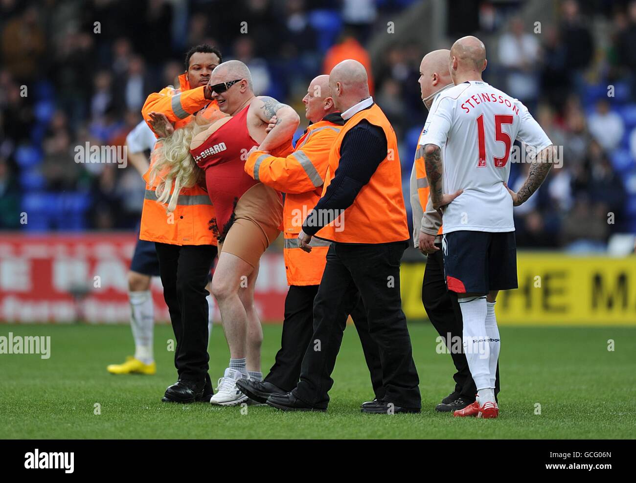 Fußball - Barclays Premier League - Bolton Wanderers gegen Birmingham City - Reebok Stadium. Ein Eindringling wird vom Sicherheitspersonal in Angriff genommen Stockfoto