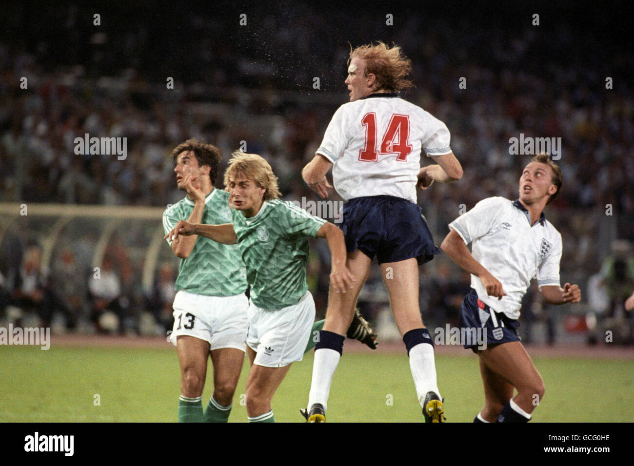 Fußball - FIFA World Cup Italia 1990 - Halbfinale - Westdeutschland gegen England - Stadio Delle Alpi. Der englische Mark Wright gewinnt den Ball vor Karlheinz RIEDLE (l) und Jürgen KLINSMANN sowie Teamkollege David Platt (r) Stockfoto