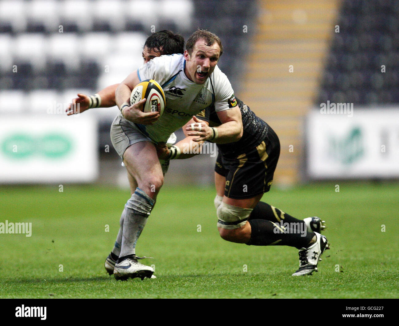 Mark McMillan von Glasgow Warriors wird von Jonathan Thomas von Ospreys während des Spiels der Magners League im Liberty Stadium in Swansea gefangen. Stockfoto