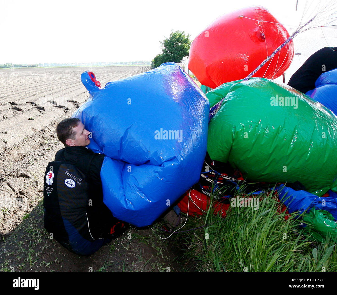 Jonathan Trappe mit seinem Ballon nach der Landung auf Ackerland in Moeres, Frankreich. Der wagemutige Abenteurer hob vom Kent Gliding Club in Challock bei Ashford ab und überquerte den Ärmelkanal, der in einem Stuhl unter mehreren Dutzend mit Helium gefüllter Ballons festgeschnallt war. DRÜCKEN Sie VERBANDSFOTO. Bilddatum: Freitag, 28. Mai 2010. Siehe PA Geschichte ABENTEUER Ballons. Bildnachweis sollte lauten: Gareth Fuller/PA Wire Stockfoto