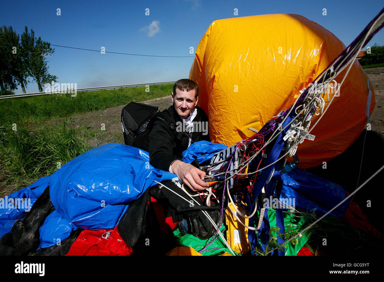 Jonathan Trappe mit seinem Ballon nach der Landung auf Ackerland in Moeres, Frankreich. Der wagemutige Abenteurer hob vom Kent Gliding Club in Challock bei Ashford ab und überquerte den Ärmelkanal, der in einem Stuhl unter mehreren Dutzend mit Helium gefüllter Ballons festgeschnallt war. Stockfoto