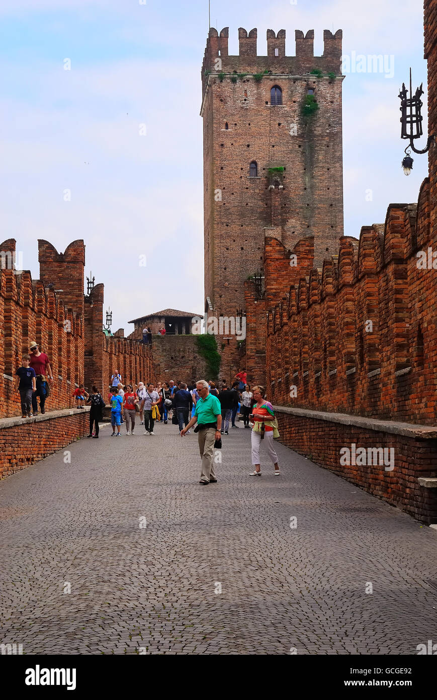 Verona, Italien. Burg Castelvecchio. Es ist die wichtigste militärische Konstruktion der Scaliger-Dynastie, die die Stadt im Mittelalter regiert. Das Schloss ist leistungsstark und kompakt in seiner Größe mit sehr wenig Deko - Quadrat Verbindung in roten Ziegeln, eines der prominentesten Beispiele der gotischen Architektur des Alters, mit imposanten M-förmigen Zinnen entlang der Burg und Brücke Mauern gebaut. Es hat sieben Türme mit vier Hauptgebäuden innerhalb einer überhöhten halten (Maschio). Das Schloss ist umgeben von einem Graben, jetzt trocken, die einmal mit Wasser aus dem nahe gelegenen Adige gefüllt war. Stockfoto