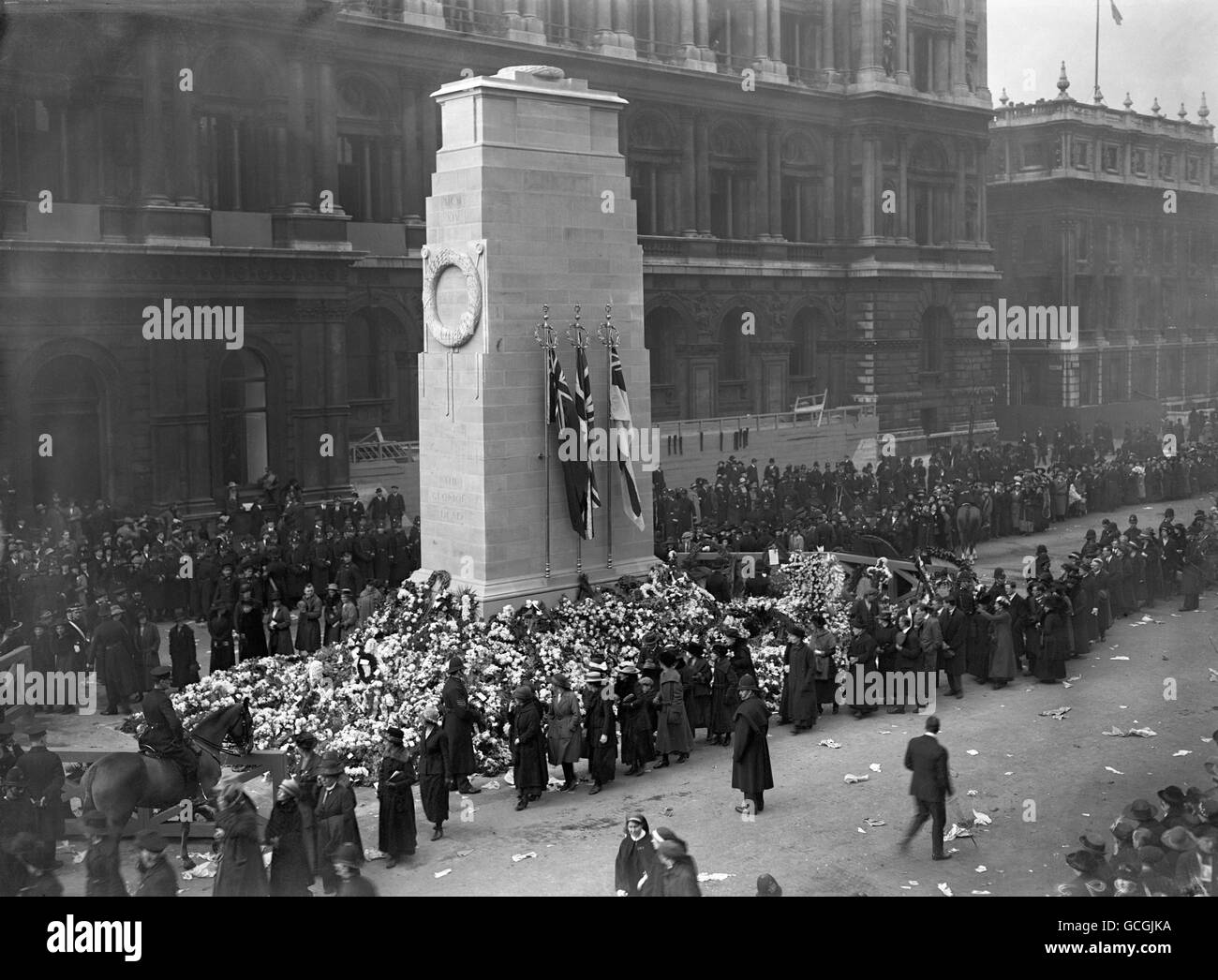 Mitglieder der öffentlichen Einreichung vorbei an der Kranz beladenen Basis des Cenotaph am Waffenstillstandstag. Stockfoto