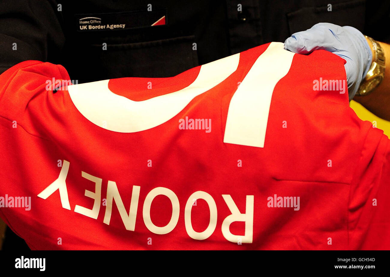Ein Offizier der britischen Grenzbehörde inspiziert gefälschte englische Fußballtrikots, die am Coventry International Postal Hub beschlagnahmt wurden. Stockfoto