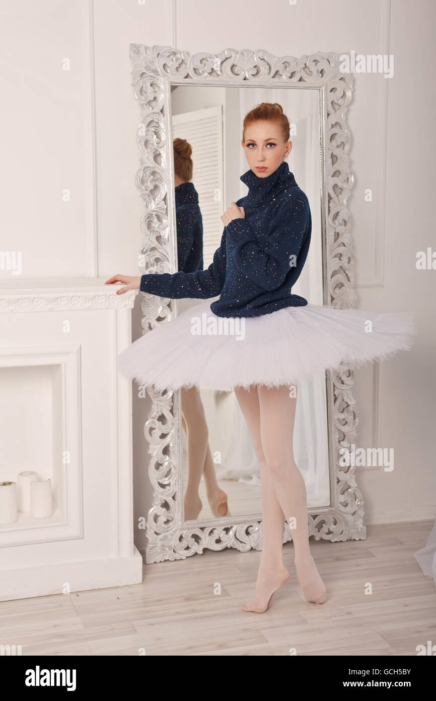 Hübsche junge Ballerina stehend vor einem Spiegel. Ein Mädchen trägt ein  Tutu und einem schwarzen Pullover Stockfotografie - Alamy