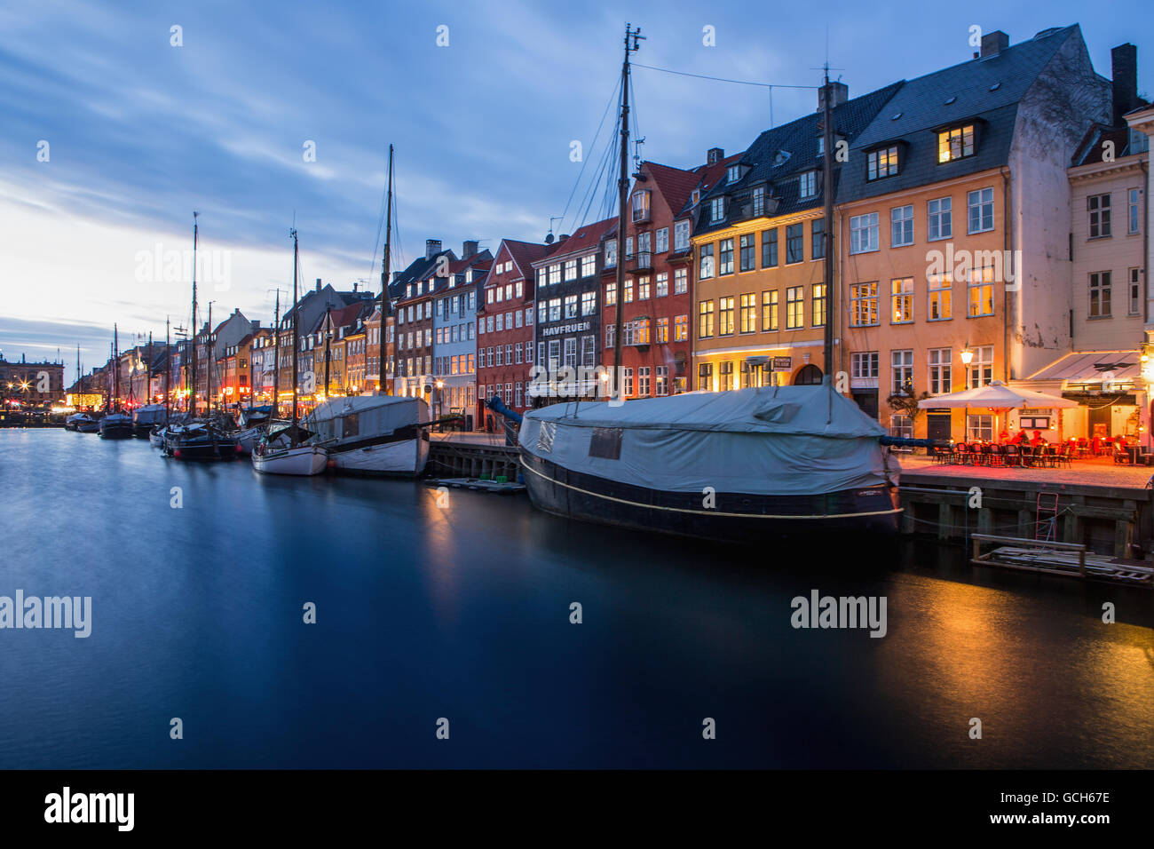 Nyhavn, dem berühmten Waterfront-Kanal in Kopenhagen mit bunten siebzehnten und achtzehnten Jahrhundert Stadthäuser entlang des Kanals in der Abenddämmerung Stockfoto