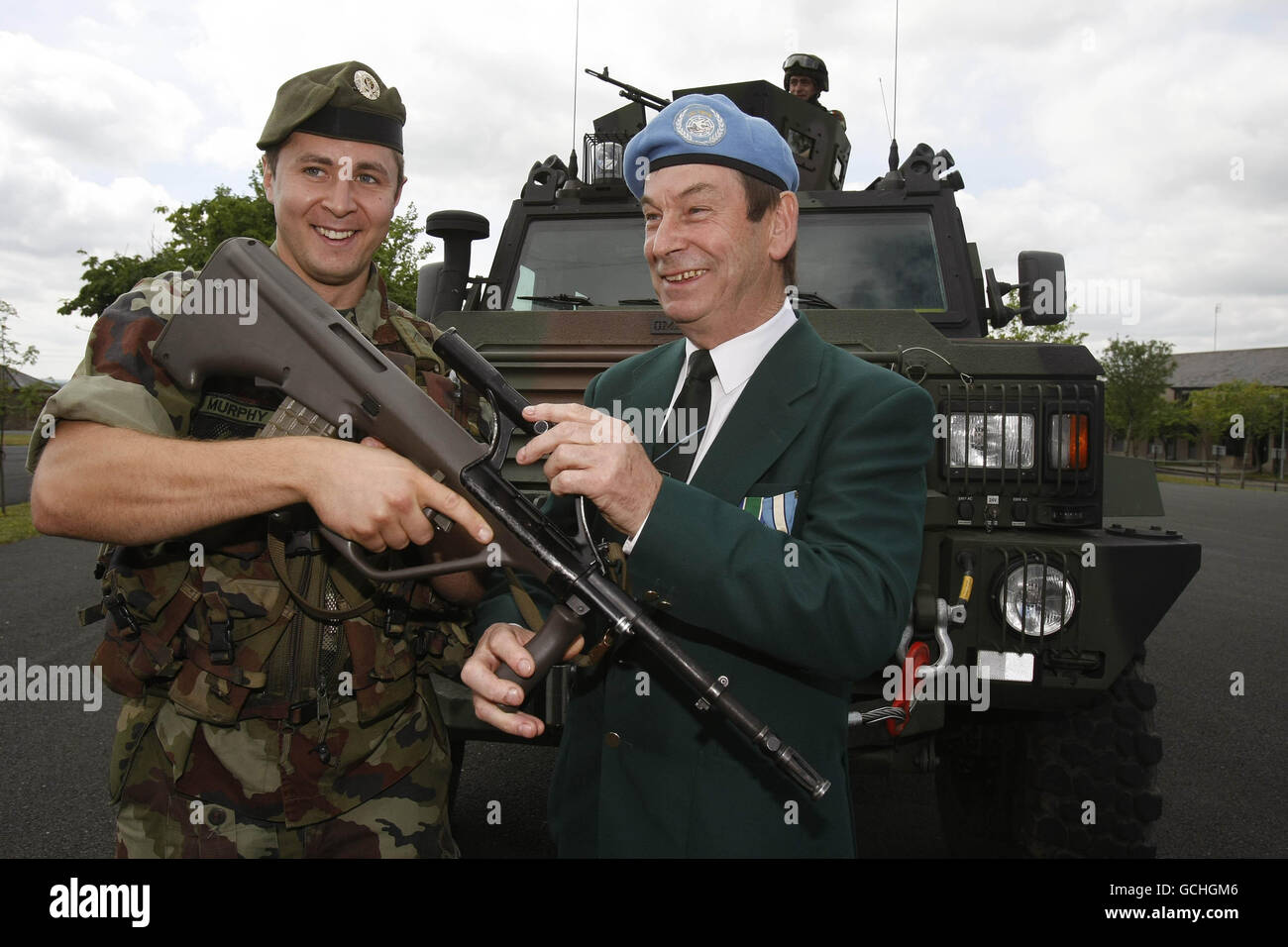 (Von links nach rechts) der Trooper Stephen Murphy und der UN-Kongo-Veteran John O'Reilly tauschen während einer Fotoaktion im Curragh Camp die Gewehre aus, um die Gedenkzeremonie der Verteidigungskräfte zu starten, die zum 50. Jahrestag der Entsendung der Verteidigungskräfte in den Kongo, Irlands erste bewaffnete Friedensmission, begangen wird. Stockfoto