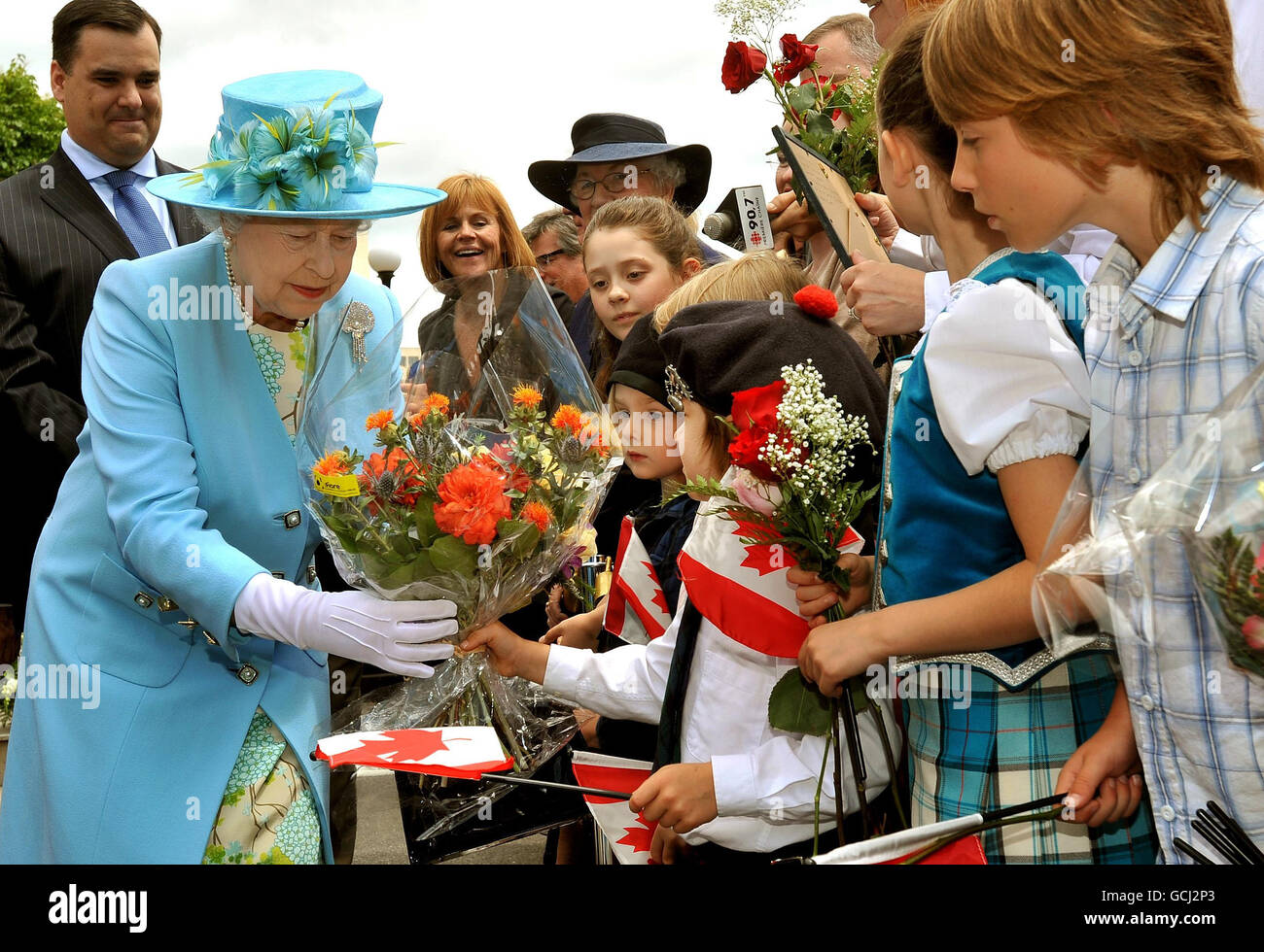 Queen Elizabeth II wird von Kindern Blumen geschenkt, nachdem sie eine Statue von Oscar Peterson, dem legendären kanadischen Jazzpianisten, enthüllt hat, nachdem sie sie im Stadtzentrum von Ottawa, Kanada, enthüllt hat. Stockfoto