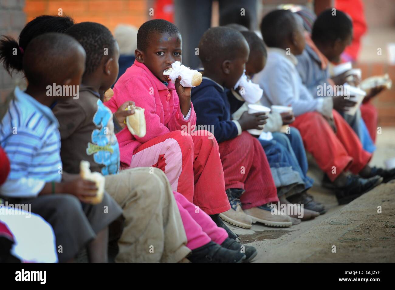 Verwaiste und gefährdete Kinder nehmen an einem Projekt von Save the Children Teil, das ihnen Essen und Trinken und einen sicheren Ort zum gemeinsamen Spielen bietet, an einer Schule in der Stadt Parys im Freistaat Südafrika. Stockfoto