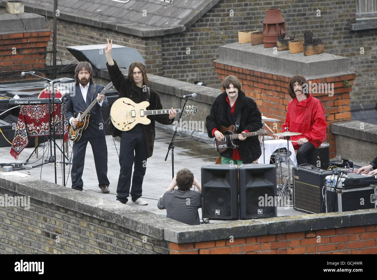 (Von links nach rechts) Fran King als Paul McCartney, Scott Maher als John Lennon, Rob McKinny als George Harrison und Binder als Ringo Starr die Besetzung von "Get Back - The Story of the Beatles" treten auf dem Dach des Dublin Olympia Theatre auf, um ihre Show zu promoten, die von Mittwoch, 4. August bis Sonntag, 8. August stattfindet. Stockfoto