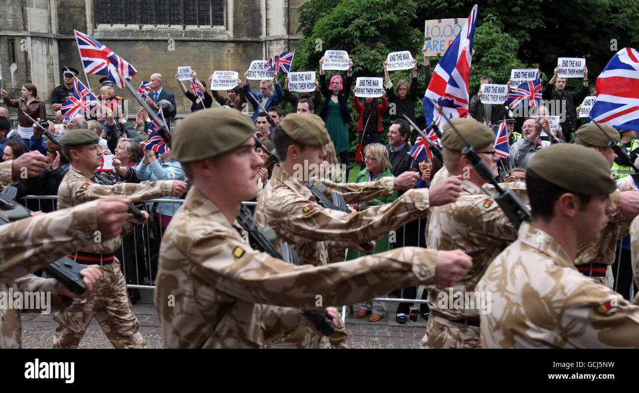 Anti-Kriegs-Demonstranten als Militärangehörige des 1. Bataillons das Royal Anglian Regiment marschiert durch das Zentrum von Cambridge, Cambridgeshire, um ihre Rückkehr aus Afghanistan zu markieren. Stockfoto