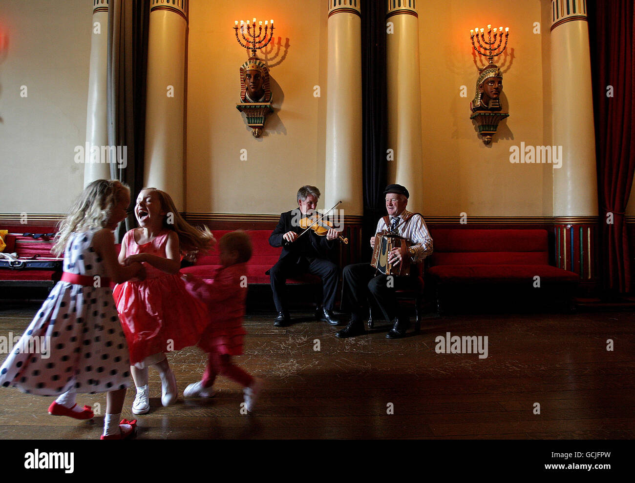 Dermot McLoughlin (Mitte links), CEO des Temple Bar Trust und des Königs von Tory Island, Dan Patsy Mac Ruairi (Mitte rechts) und spielt Musik für Kinder Aliesha Smith, Hazel Donegan und Jade Smith tanzen in der Grand Lodge of Freimaurers of Ireland bei der Fotocall, um die Temple Bar Trust's Culture Night 2010 zu starten. In der Nacht werden Dutzende von Kulturzentren für die Öffentlichkeit zugänglich sein. Stockfoto