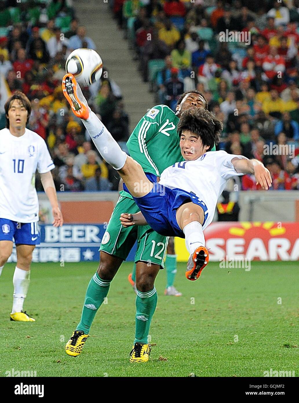 Die nigeranische Kalu Uche versucht, den Overhead-Kick zu blockieren Dong-Jin Kim aus Südkorea Stockfoto