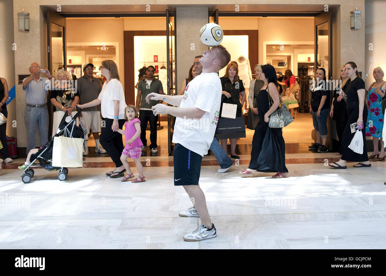 Dan Magness, der den Guinness-Weltrekord hält, weil er 26 Stunden lang Fußball gespielt hat, versucht den Weltrekord für die meisten aufeinanderfolgenden Berührungen auf der Schulter mit 506 Berührungen im Brent Cross Shopping Centre im Norden Londons, als Teil der Love Football, Love Fashion Promotion des Shopping Centers. Stockfoto