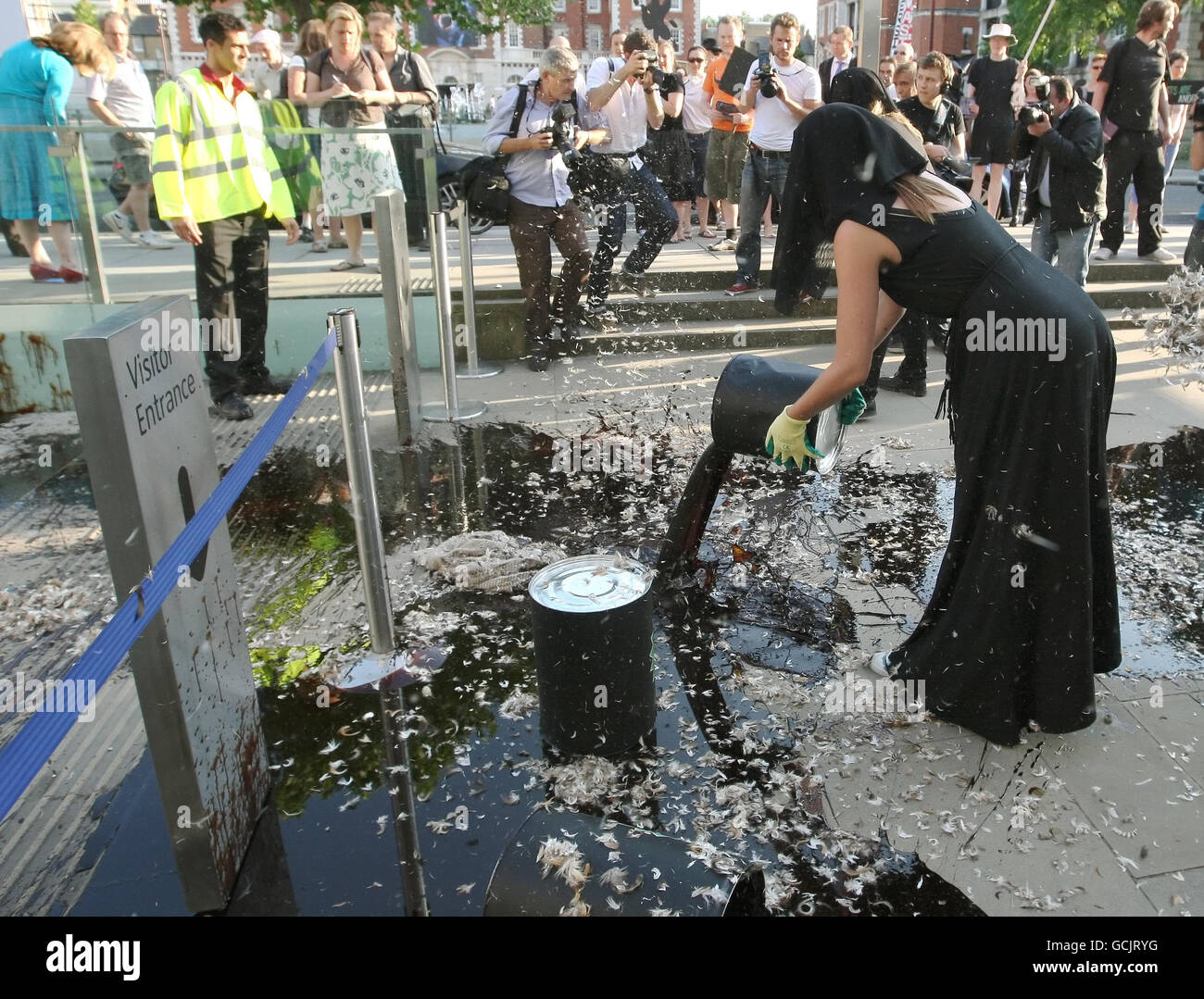Demonstranten schütten Öl und Federn vor den Eingang der Tate Britain in Pimlico, im Zentrum von London, wo die Tate Britain Sommerparty veranstaltet wird, als Teil eines Protests gegen BP-Sponsoring der Künste Stockfoto