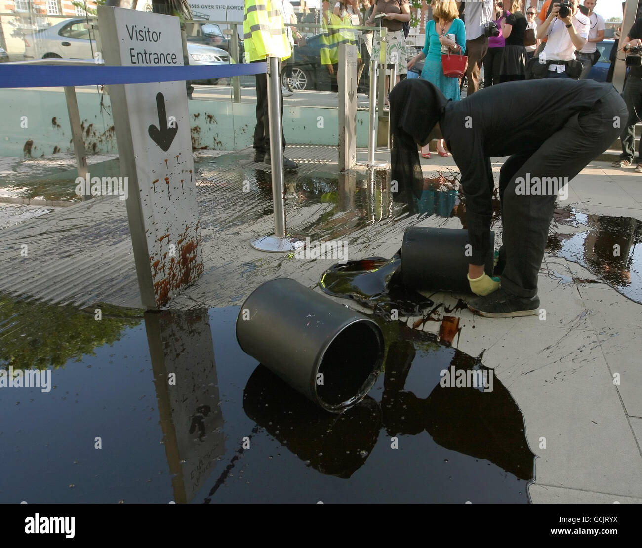 Demonstranten schütten Öl und Federn vor den Eingang der Tate Britain in Pimlico, im Zentrum von London, wo die Tate Britain Sommerparty veranstaltet wird, als Teil eines Protests gegen BP-Sponsoring der Künste Stockfoto