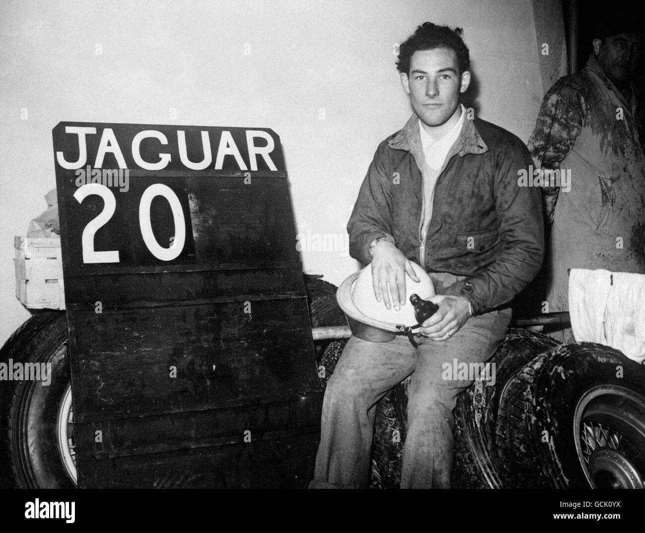 Der britische Fahrer Stirling Moss setzt sich zu einem Bier hin Nachdem sein Jaguar XK-120C danach aus dem Rennen ausgeschieden war 92 Runden Stockfoto