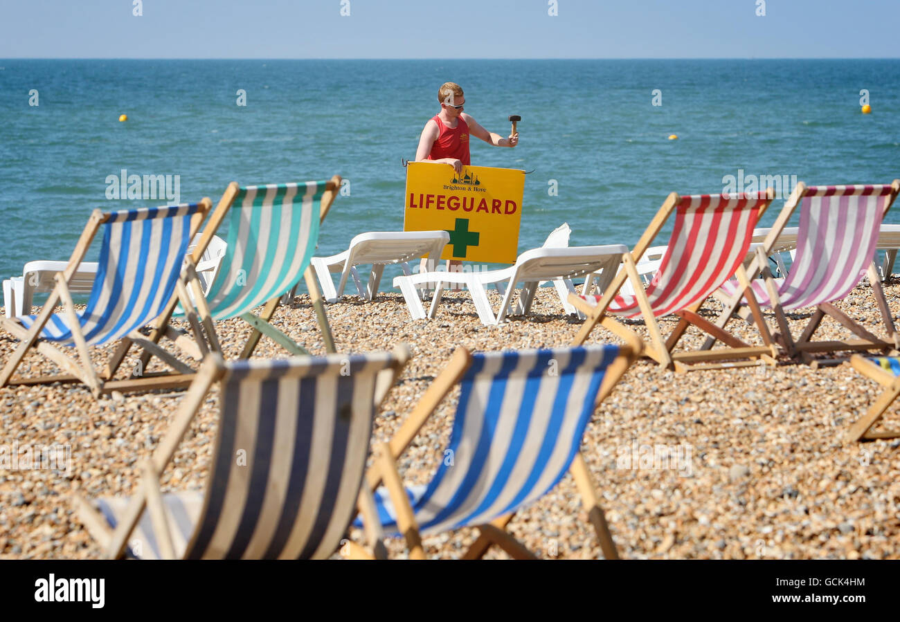 Ein Rettungsschwimmer legt am Brighton Beach in Brighton, Sussex, ein Schild auf, da sich ein Großteil Englands auf ein Wochenende mit heißem Wetter vorbereitet. Stockfoto