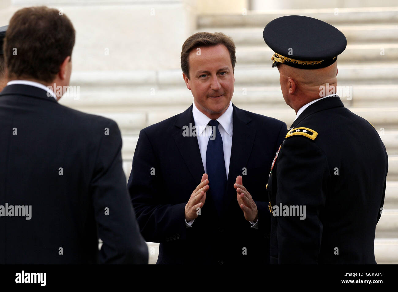 Der britische Premierminister David Cameron (Mitte) während einer Tour durch den Arlington National Cemetery, nachdem er während einer Kranzniederlegung auf dem Arlington National Cemetery in Arlington, Virginia, einen Kranz am "Grab der Unbekannten" im Rahmen seines zweitägigen Besuchs in den USA niedergelegt hatte. Stockfoto